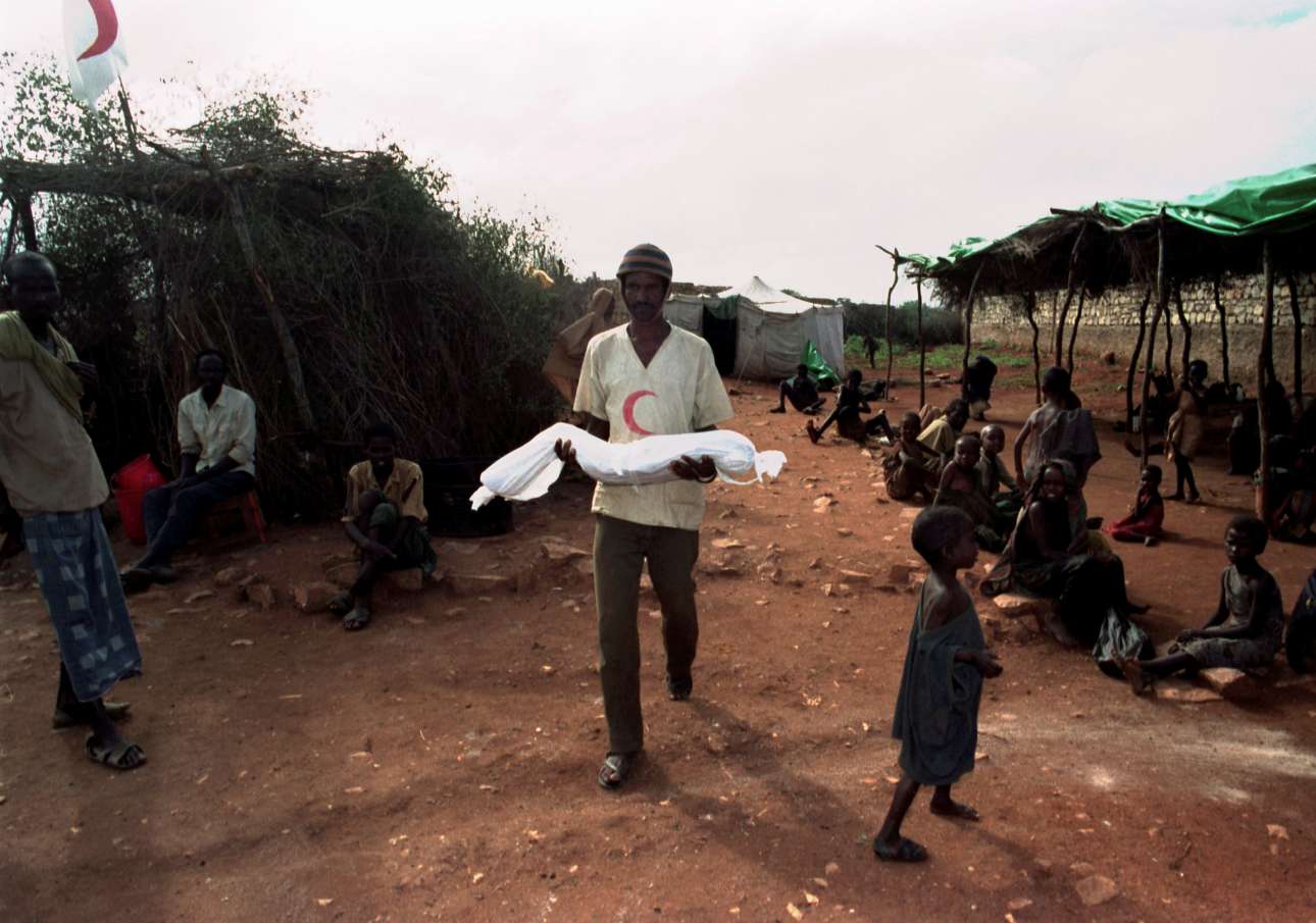 Όταν ο θάνατος ενός παιδιού είναι μια καθημερινότητα: εργαζόμενος στην ανθρωπιστική βοήθεια μεταφέρει για ταφή ένα παιδί που πέθανε σε στρατόπεδο προσφύγων στη Σομαλία, στις 15 Δεκεμβρίου 1992