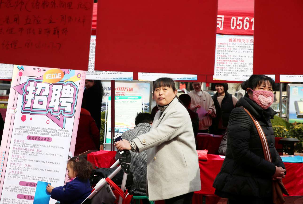 Περαστικές διαβάζουν τις αγγελίες για εύρεση εργασίας σε εκδήλωση για άνεργες γυναίκες στο Χιουαμπέι της Κίνας