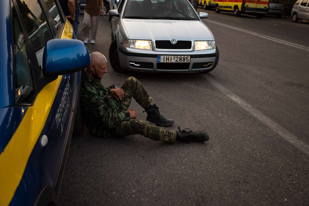Ένας εξαντλημένος εθελοντής δασοπυροσβέστης ξεκουράζεται πριν ξαναριχτεί στη μάχη στη Βαρυμπόμπη