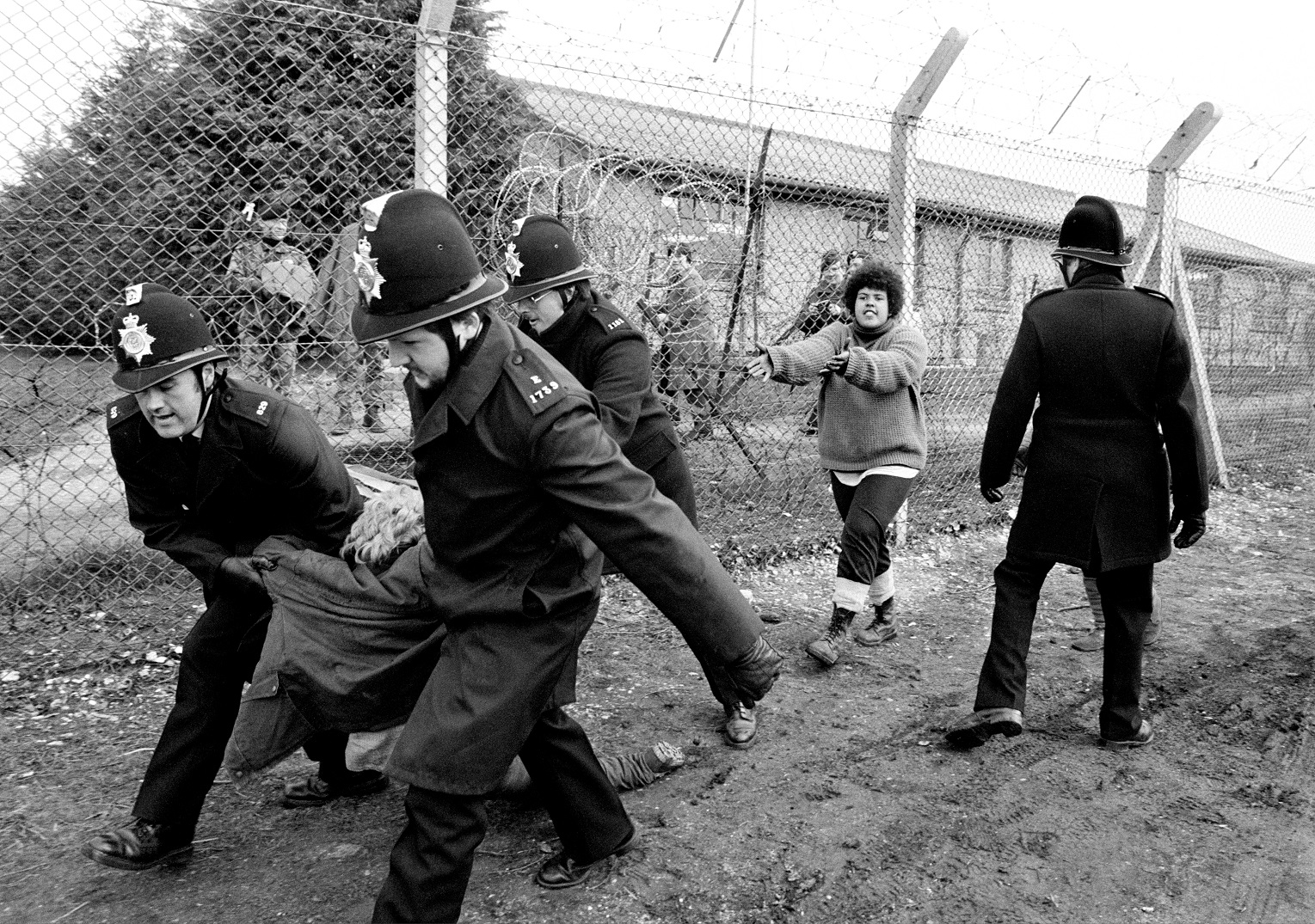 Δεκέμβριος 1983: Μια διαδηλώτρια συλλαμβάνεται, ενώ μία άλλη εκλιπαρεί για την απελευθέρωσή της κατά τη διάρκεια αντιπυρηνικής διαδήλωσης στην αεροπορική βάση Greenham Common στο Berkshire