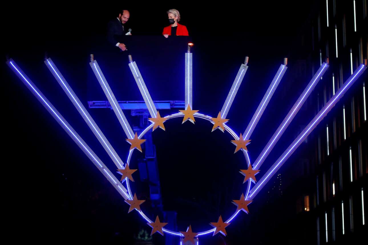 Η γερμανίδα πρόεδρος της Κομισιόν Ούρσουλα φον ντερ Λάιεν επί ανυψωτικού μηχανήματος, δίπλα σε ραβίνο που ανάβει τα κεριά της εβραϊκής εννιάφωτης λυχνίας «Χανουκά» –  ένα καρέ από τις Βρυξέλλες, έδρα της Ευρωπαϊκής Ενωσης