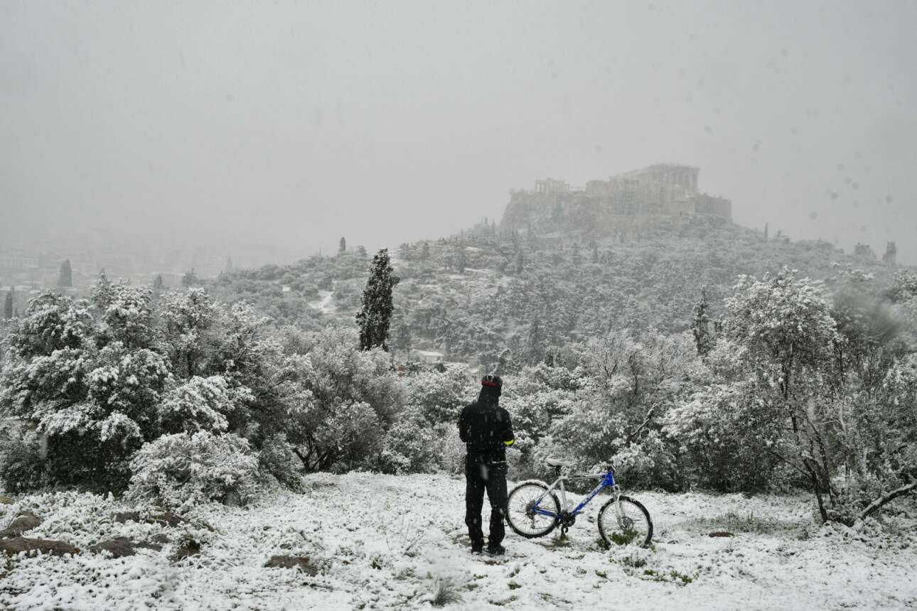 Διάλειμμα στην ποδηλατάδα για μια θέα στη χιονισμένη Ακρόπολη