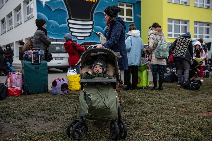 Γυναικόπαιδα από την Ουκρανία μόλις έχουν φθάσει στην Πολωνία με την ιδιότητα των προερχομένων από εμπόλεμη ζώνη προσφύγων και περιμένουν στη σειρά ώστε να λάβουν οδηγίες σχετικά με τη φιλοξενία τους 