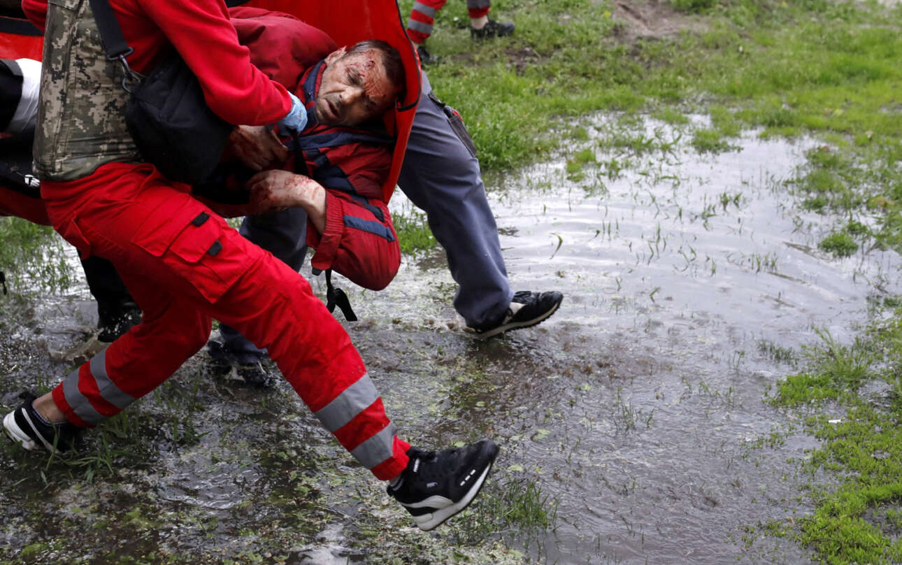 Ιατρικό προσωπικό μεταφέρει έναν τραυματισμένο άντρα μετά από ρωσικό βομβαρδισμό στο Χάρκοβο