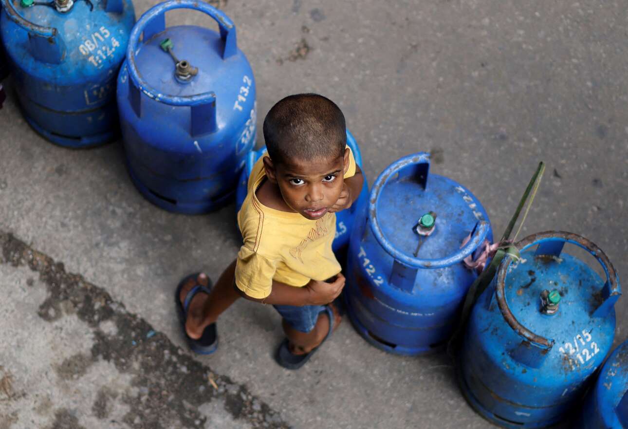 Οι φιάλες υγραερίου είναι άδειες, και ο μικρός με το ατρόμητο βλέμμα περιμένει στην ουρά για να γεμίσει τη δική του – η Σρι Λάνκα δονείται από οργή λαού για την οικονομική κρίση, όμως αυτές δεν μπορούν να εκραγούν 