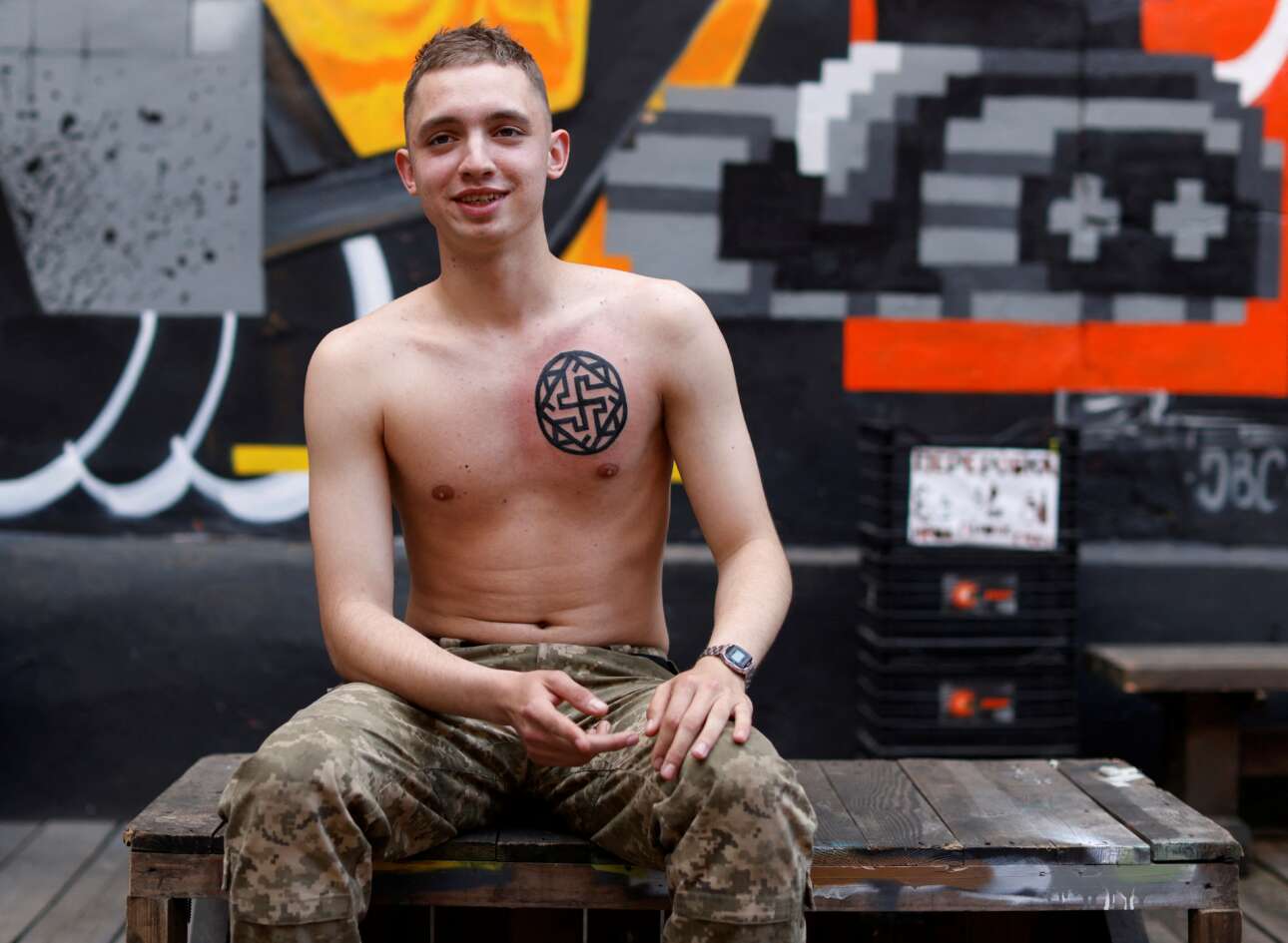 Στο Κίεβο οι Ουκρανοί έκαναν έναν «μαραθώνιο των τατουάζ» με σκοπό να συγκεντρώσουν λεφτά για τον στρατό τους: ο εικονιζόμενος νεαρός σταμπάρισε το στήθος του με αυτό το σύμβολο – το Reuters το χαρακτήρισε «παλιό σλαβικό» καθώς δεν είναι παλαιογερμανική σβάστικα, πόσο μάλλον αρχαιοελληνικό γαμμάδιον