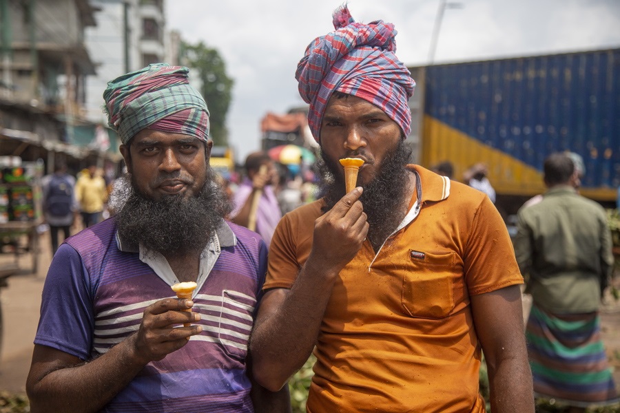 Μεροκαματιάρηδες δροσίζονται με παγωτό χωνάκι στην καυτή Ντάκα του Μπανγκλαντές – η ταπεινή απόλαυση των δύο εργατών διεκόπη (όχι τζάμπα, ελπίζουμε) ένεκα της φωτογραφικής ενημέρωσής μας