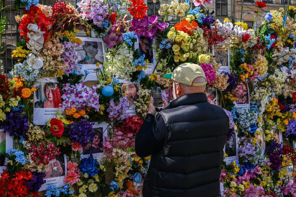 Ενας τοίχος γεμάτος λουλούδια και φωτογραφίες στην πόλη Λβιβ - φόρος τιμής στη μνήμη των θυμάτων των ρωσικών επιθέσεων
