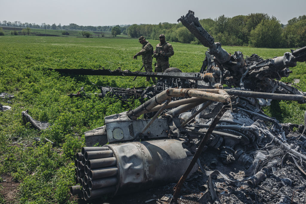 Ουκρανοί στρατιώτες περπατούν δίπλα στα συντρίμμια ρωσικού ελικόπτερου που καταρρίφθηκε στα περίχωρα του Χαρκόβου