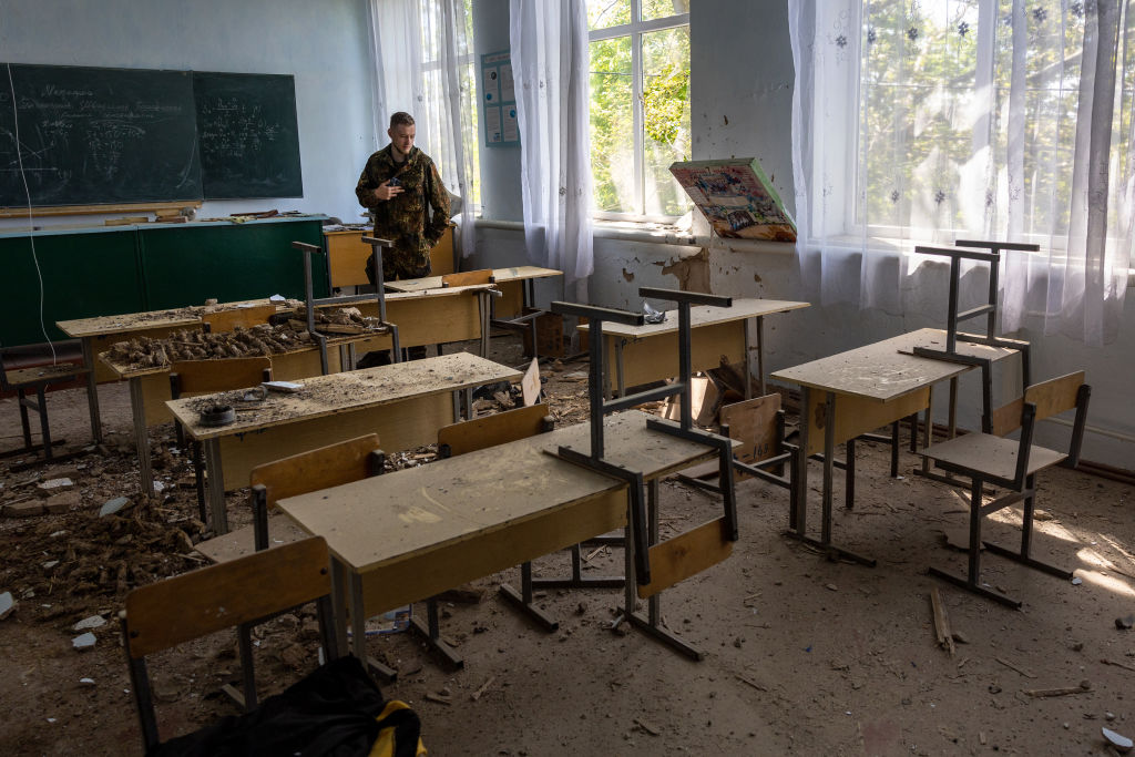 Στρατιώτης επιθεωρεί μια κατεστραμμένη τάξη σε σχολείο της Kοτσουμπέιβκα, στην Ουκρανία. Οι Ρώσοι κατέλαβαν την κομβικής σημασίας περιφέρεια της Χερσώνας προκειμένου να δημιουργήσουν έναν χερσαίο διάδρομο από την Κριμαία ως τις περιοχές που ελέγχονται από αυτονομιστές, στα ανατολικά