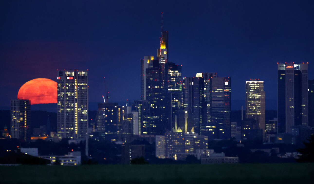 Η Πανσέληνος της Φράουλας υψώνεται πίσω από τους ουρανοξύστες της Φρανκφούρτης στη Γερμανία