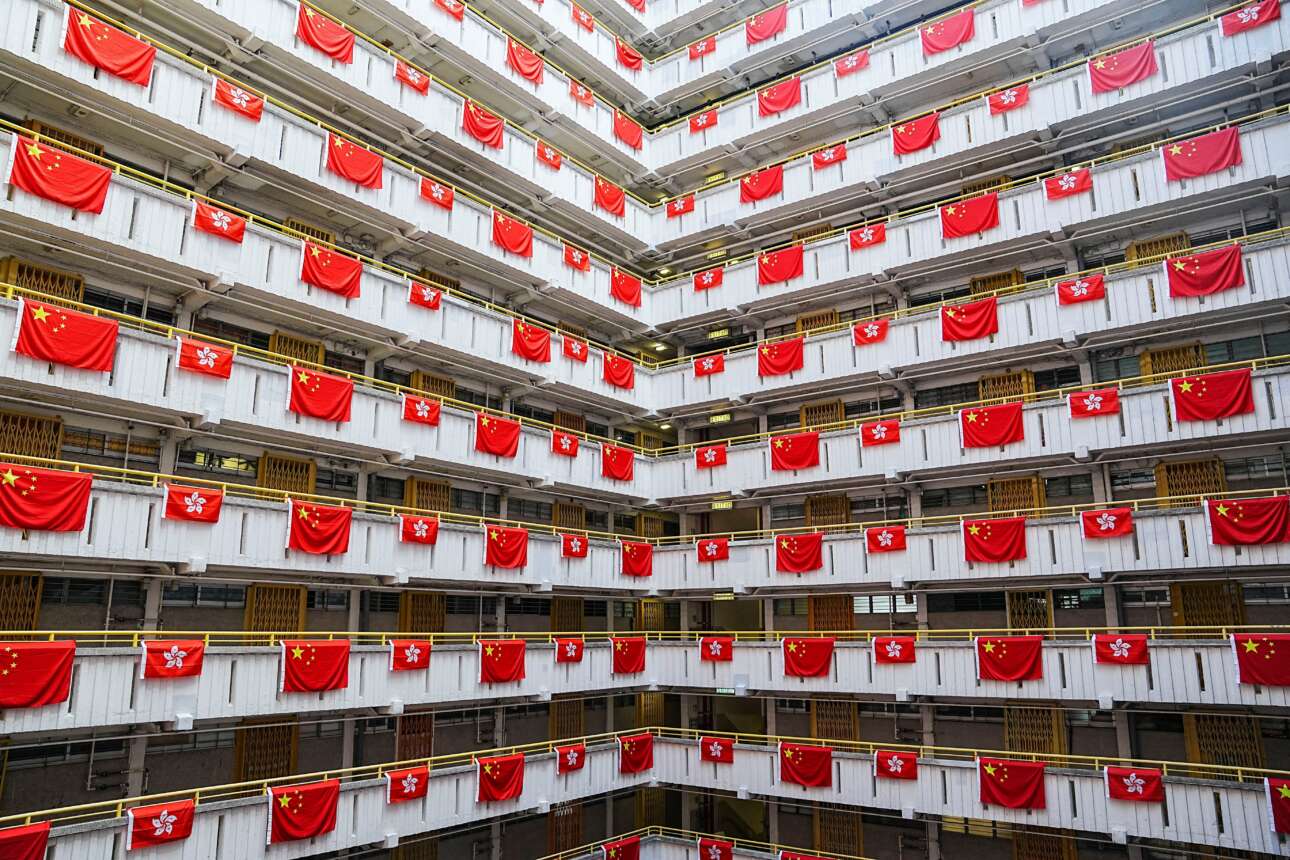 Οργανωμένοι πανηγυρισμοί στις πολυκατοικίες του Χονγκ Κονγκ, διότι εορτάζεται η 25η επέτειος της παραδόσεώς του στην Κίνα (από τη Βρετανία): μετρήστε με το υποδεκάμετρο την ευταξία του σημαιοστολισμού και θαυμάστε το μελετημένο μέγεθος των λαβάρων – η σημαία της κινεζικής επαρχίας είναι περίπου στο μισό της εθνικής 