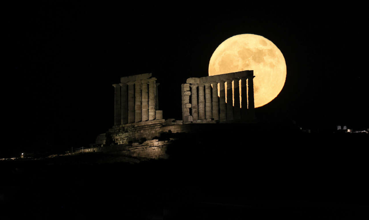 Η Πανσέληνος του Ιουνίου υψώνεται μεγαλοπρεπής πίσω από τον Ναό του Ποσειδώνα στο Σούνιο