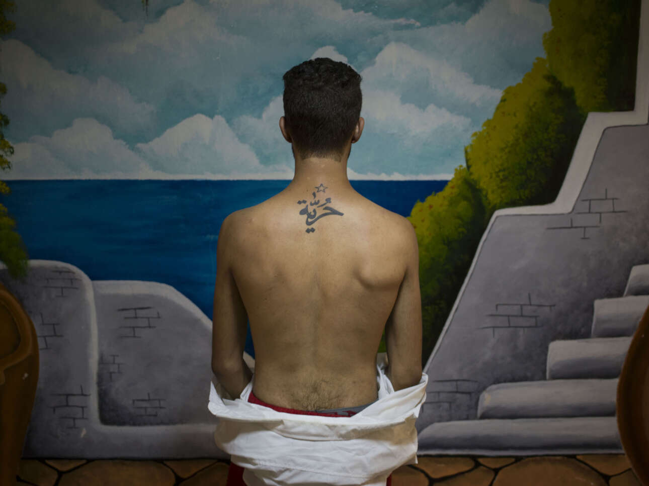 Ενας νεαρός ηθοποιός που συνεργάζεται με την ομάδα Fani Raghman Ani, μια οργάνωση που υπερασπίζεται τα ανθρώπινα δικαιώματα στην Τυνησία, δείχνει το τατουάζ στην πλάτη του που γράφει «ελευθερία» στα αραβικά