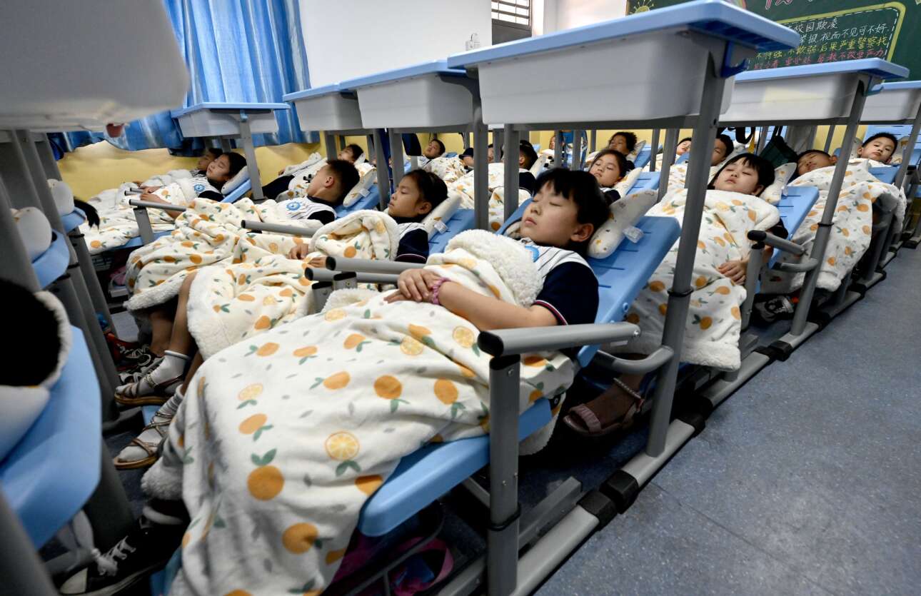 Παιδιά του Δημοτικού στην πόλη Χαντάν της Κίνας ασκούνται στον υποχρεωτικό μεσημβρινό ύπνο μέσα στην τάξη τους – χάρις στην πατέντα ενός επινοητικού μυαλού, κρεβατάκια τους έγιναν οι καρέκλες του θρανίου τους