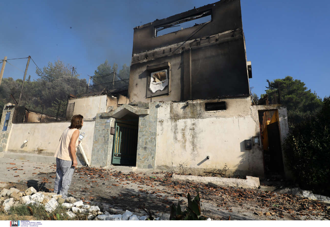 Κάτοικος της Ανθούσας κοιτάζει το κατεστραμμένο σπίτι της