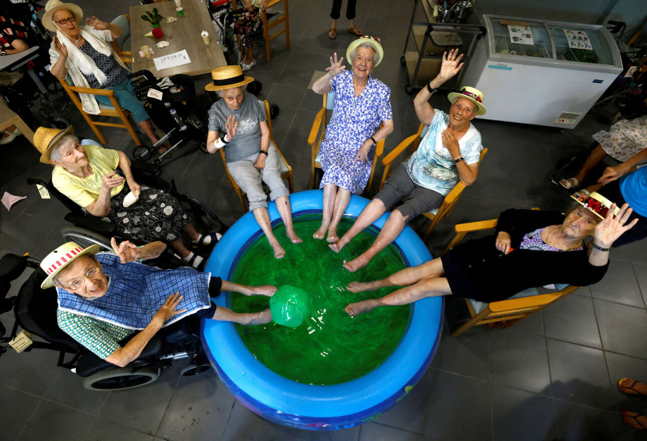 Ηλικιωμένοι βρέχουν τα πόδια τους στη φουσκωτή πισίνα του γηροκομείου όπου ζουν για να δροσιστούν από τον καύσωνα στο Βέλγιο