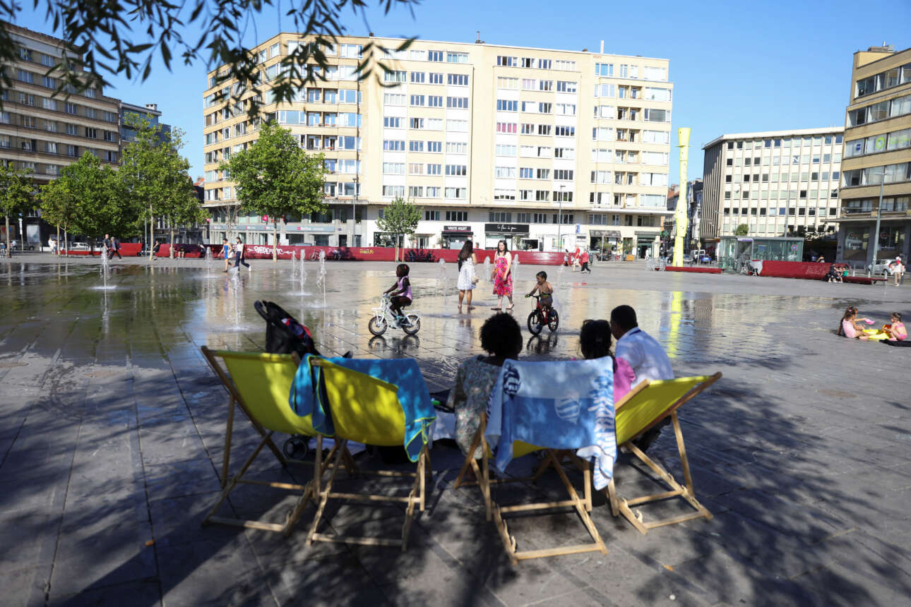 Πολίτες του Βελγίου βρίσκουν δροσιά τις πιο ζεστές ώρες της μέρας κοντά σε σιντριβάνι 