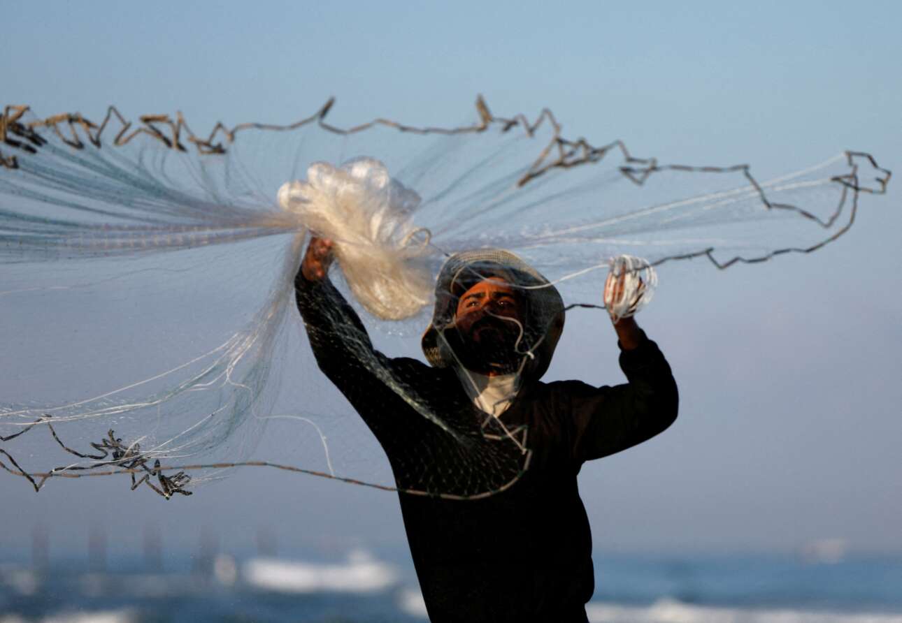 Παλαιστίνιος ψαράς της Γάζας ρίχνει το δίχτυ του στα ρηχά, από την παραλία: μόνο για αφρόψαρα πάει μάλλον, μήπως βγάλει καμιά τηγανιά –και, πάλι, ο Θεός του μεγάλος θα είναι–, αφού τέτοιο ψάρεμα είναι περισσότερο απελπισμένο παρά πρακτικό, με ασήμαντες πιθανότητες επιτυχίας (φυσικά, μπορεί να είναι και στημένο κλικ, σκηνοθετημένο από τον φωτογράφο)