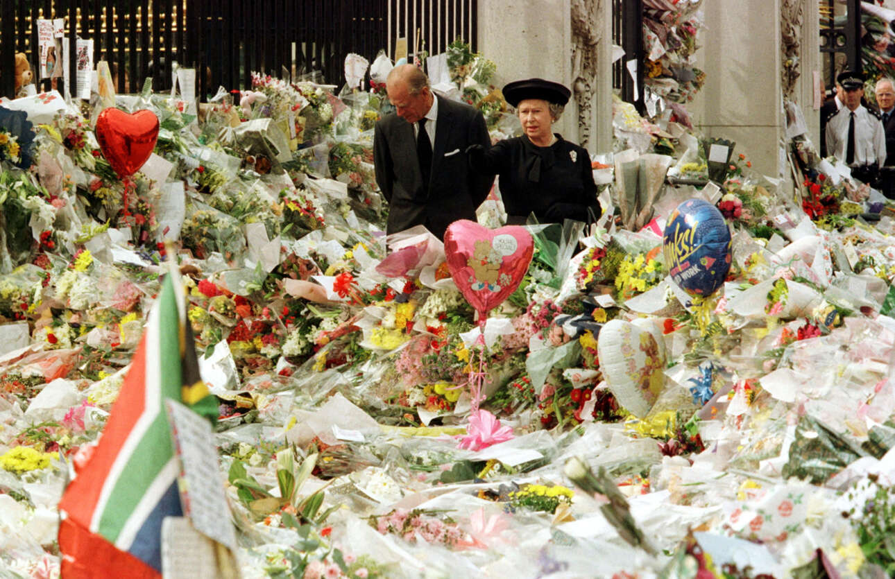 Η βασίλισσα Ελισάβετ Β' και ο δούκας του Εδιμβούργου κοιτάζουν τo «βουνό» από λουλούδια που έχει συγκεντρωθεί έξω από τα Ανάκτορα του Μπάκιγχαμ στη μνήμη Νταϊάνα, μετά τον θάνατό της, τον Σεπτέμβριο του 1997