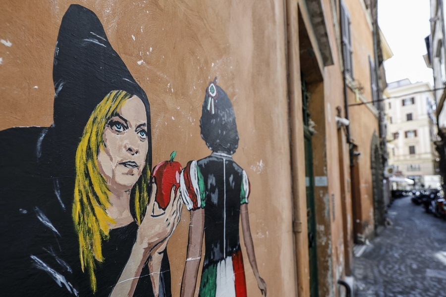 Προεκλογικό «φρέσκο» σε τοίχο της Ρώμης δείχνει τη «φασίστρια» Τζόρτζια Μελόνι των «Αδελφών» σαν κακιά μάγισσα ή φθονερή βασίλισσα προσφέρουσα το δηλητηριασμένο μήλο του πολιτικού ληθάργου στην κατά τα λοιπά άσπιλη, αμόλυντη και «Χιονάτη» Ιταλική Δημοκρατία – «και αν δεν είναι αληθινό, είναι πετυχημένο» όπως λένε οι Ιταλοί, τόσο οι ποιητές όσο και οι μαφιόζοι