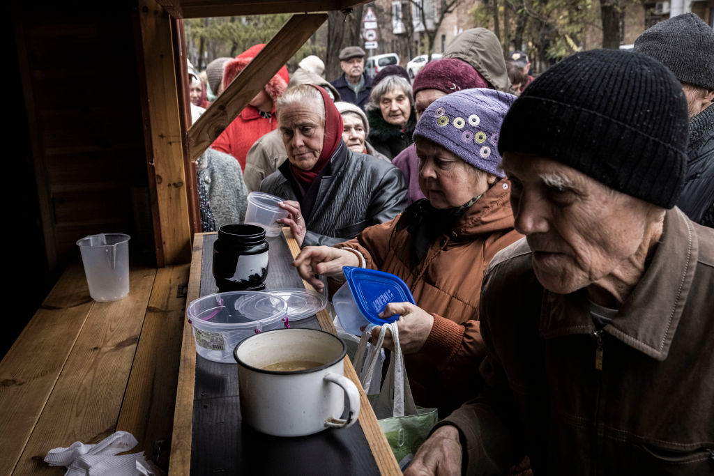 Συνταξιούχοι περιμένουν στην ουρά για δωρεάν σούπα, ψωμί και ζεστό φαγητό σε κιόσκι της φιλανθρωπικής οργάνωσης Enjoying Life