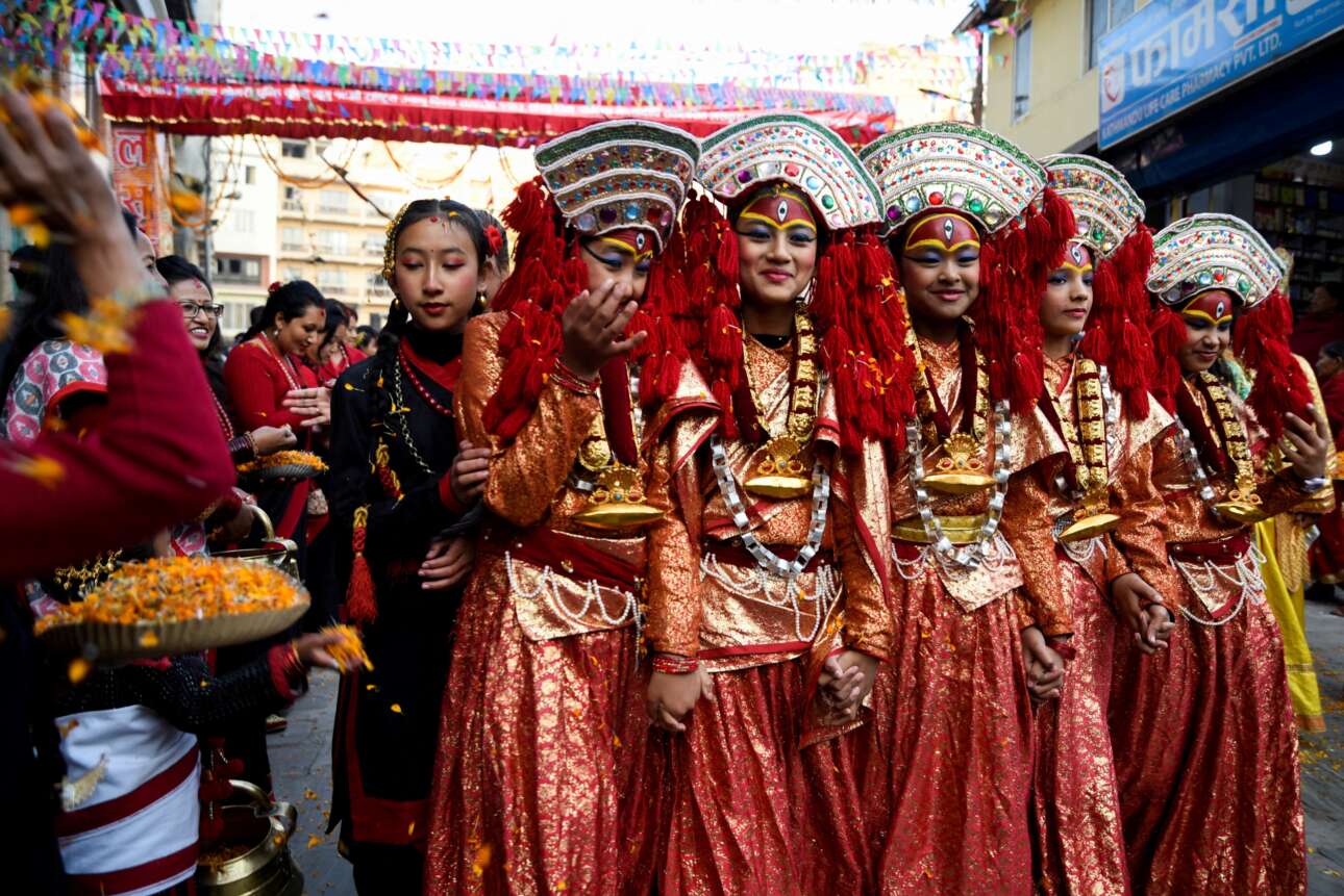 Χαριτωμένο στιγμιότυπο από φολκλορικές εκδηλώσεις στο Κατμαντού: οι εικονιζόμενες νεαρές Νεπαλέζες, φιλενάδες πιασμένες από τα χέρια, συνδυάζουν τα γλυκά χαμόγελα με τη γνήσια αιδημοσύνη μπροστά στον προπέτη φακό 