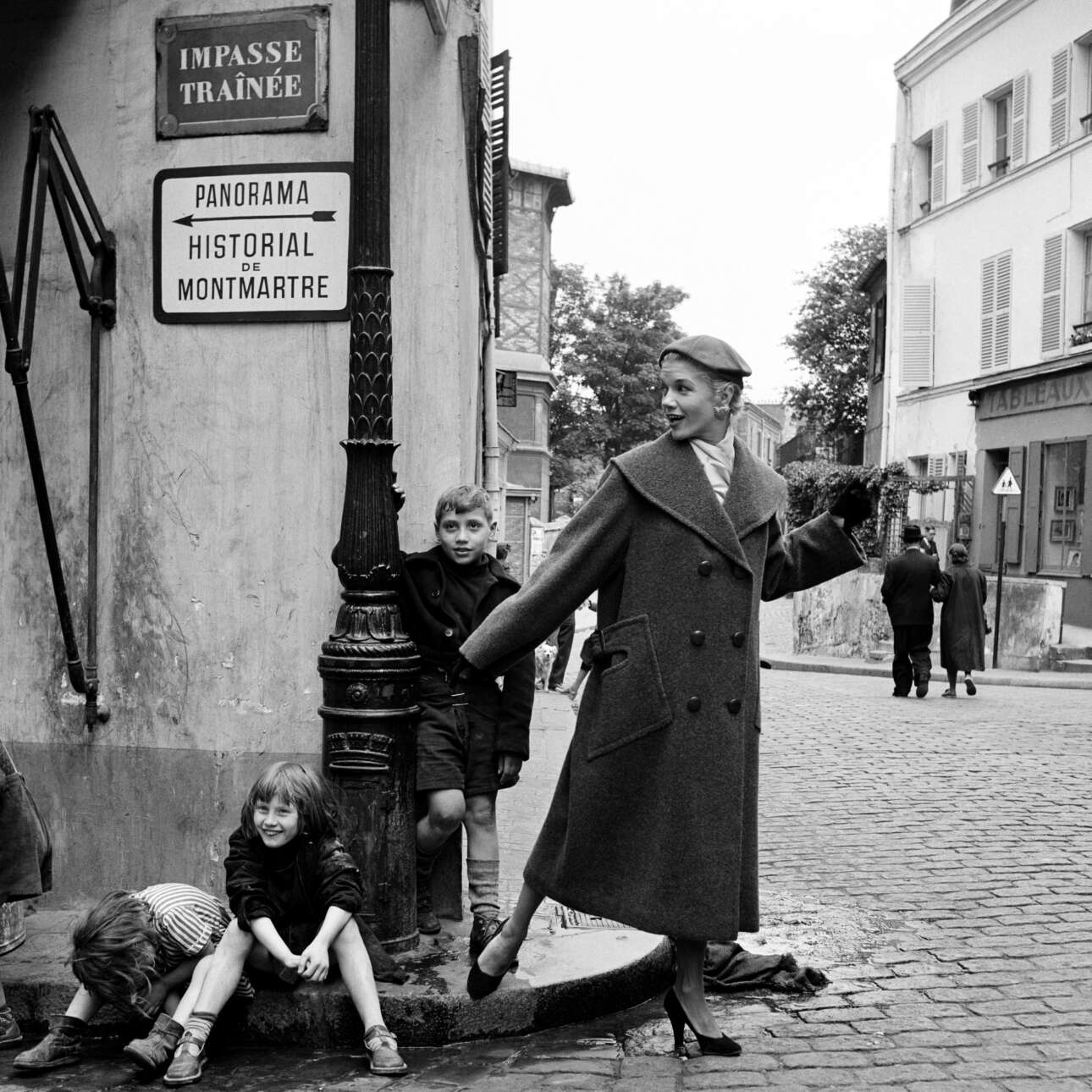 Μοντέλο ποζάρει δίπλα σε παιδιά στη Μονμάρτρη, το 1960. «Τα παιδιά στους δρόμους του Παρισιού πάντα με ακολουθούσαν για να μπουν και αυτά στο κάδρο», είχε δηλώσει η Στάφορντ