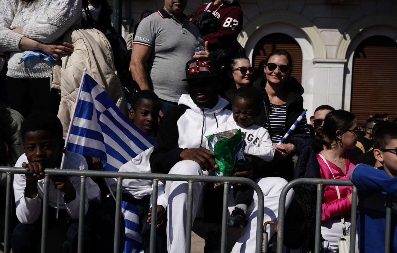 Λίγα πατατάκια, λίγο κλάμα -στην περίπτωση του μικρού- και μία ελληνική σημαία στο χέρι κατά την αναμονή της παρέλασης