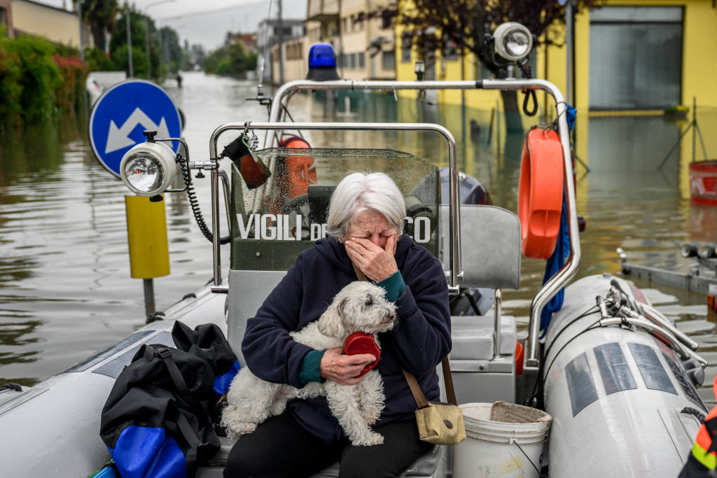 Mια ηλικιωμένη γυναίκα και το σκυλάκι της μεταφέρονται από διασώστες σε ασφαλές σημείο, μετά τις καταστροφικές πλημμύρες που έπληξαν, ανοιξιάτικα, το Λούγκο αλλά και ολόκληρη την περιοχή της Εμίλια-Ρομάνια, στην Ιταλία